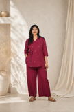 Woman wearing a maroon outfit standing in a room with neutral decor